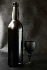 Matte black bottle of red wine on a dark background