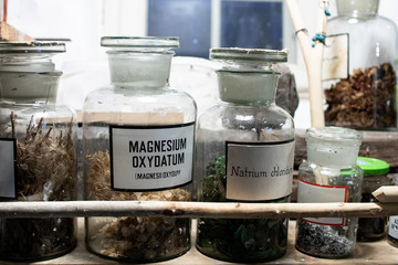 ancient pharmacist and chemical ampoules stored on wooden and dusty shelves. elements for chemicals to mix artisanal