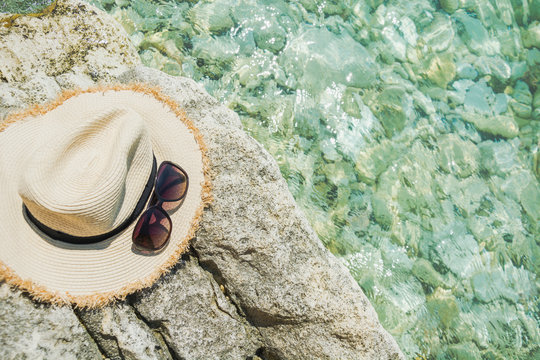 Female accessory, straw sunhat, glasses. Summer bearch vacation. Close up.