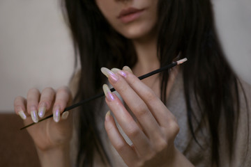 Obraz premium Sexy woman with long fingernails holding aroma incense