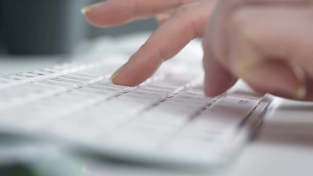 Woman hand typink on white keyboard. Work in business office close up 4k footage.