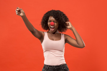 The happy surprised and smiling african woman on red nose day. The clown, fun, party, celebration,...