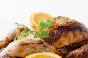 Close up of fruits and roasted chicken against white background