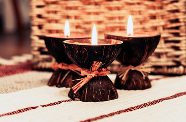 Burning spa aroma candles in coconut shell, cozy home interior .