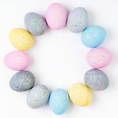 Stylish Frame of pale pink, blue and gray Easter eggs with copy space for text. Flat lay