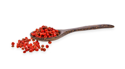 dried pink peppers in wood spoon isolated on white background