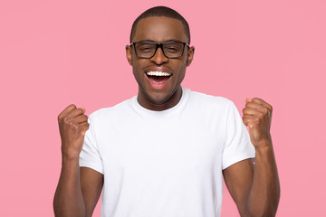 Excited overjoyed lucky black man feeling winner screaming with joy looking at camera isolated on...