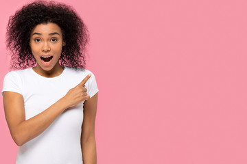 Amazed african woman pointing finger at copyspace surprised by unbelievable sale, excited female...