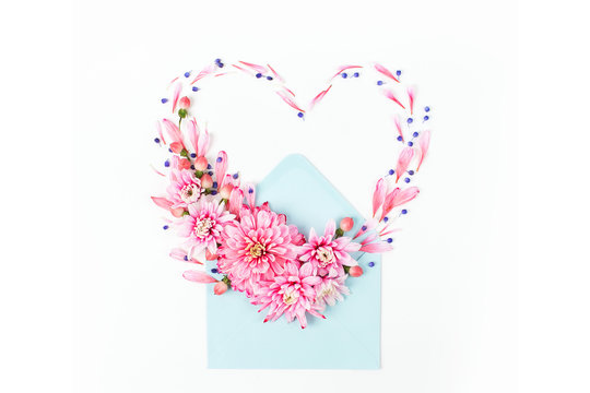 Beautiful floral arrangements. Pink chrysanthemums in the shape of heart with envelope on white background. Flat lay, top view.
