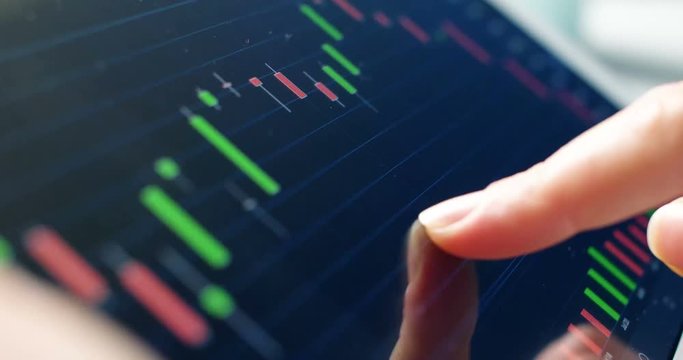 Trader working online with tablet on stock market. Close up 4k screen tablet with numbers and graphs.