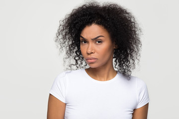 Suspicious annoyed young african american woman with distrustful face looking at camera, skeptical sarcastic black girl feeling cautious dubious distrusting isolated on grey white studio background - obrazy, fototapety, plakaty