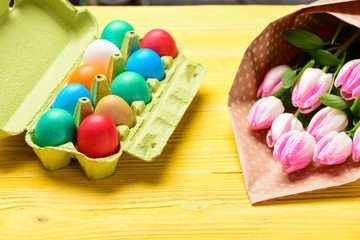 Egg hunt. painted eggs in egg tray. Spring holiday. Holiday celebration, preparation. Tulip flower bouquet. Healthy and happy holiday. Happy easter. So happy