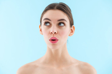Young pretty woman posing isolated over blue wall background.