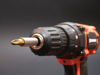 close-up of cordless screwdriver. selective focus on end of drill bit on black background