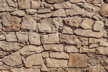 Old Stone wall background. Fragment of a historic wall made of limestone.