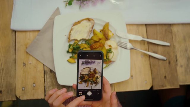 Man is taking a photo of his food 