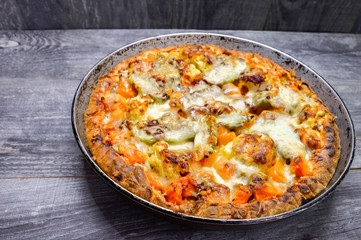 Pie with vegetables and cheese in the pan on a vintage grey wood rustic background