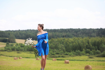 Young cute girl run in a field at sunset