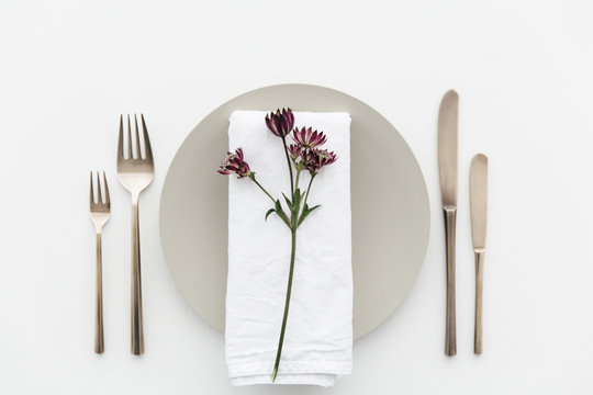 A dinner table decorated with purple flowers.