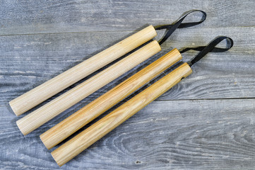Nunchucks on vintage wooden background. The concept of invitation to training.