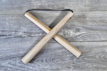 Nunchucks on vintage wooden background. The concept of invitation to training.