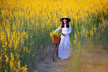 Beautiful women with traditional Vietnamese culture. Ao dai is a famous traditional costume, a walk in the forest, yellow soil nourishing plants.