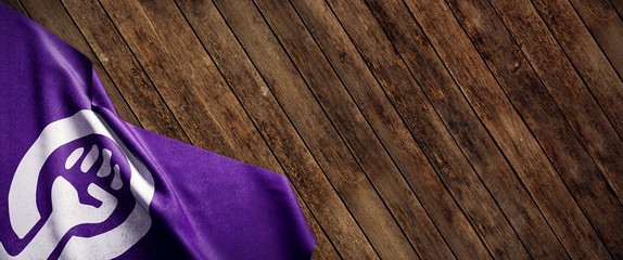 Bandera feminista sobre fondo de madera