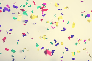 Falling confetti on creamy background.