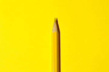 one yellow pencil on a bright yellow background with a hard shadow. stationery. view from above