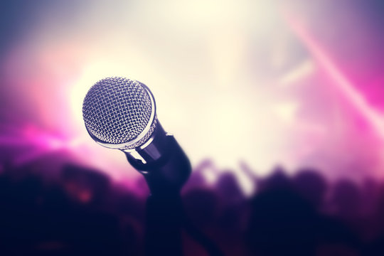 Microphone on stage, crowd of people in the club.