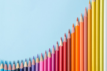 Composition with colored pencils on a bright blue background. top view. space for text.frame