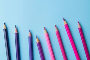 composition with multicolored pencils with pencils on a bright blue background. close-up. place for text.