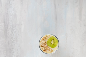 Yogurt in a glass with kiwi and nuts