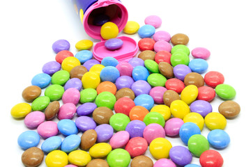 Multicolored glazed chocolate candies out of the container