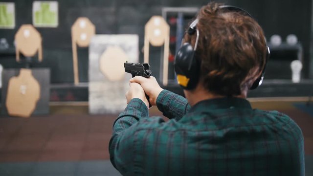 Shooting gallery. A young man shooting on a shooting range