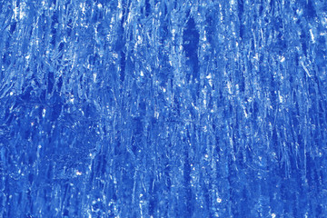 Texture of ice in winter. Pieces of frozen water on a street in the winter. The texture and texture of the frozen water in winter and outdoors.