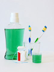 Bottle and glass of mouthwash on bath shelf with toothbrush. Dental oral hygiene concept. Set of oral care products.Flat lay composition with manual toothbrushes  and oral hygiene products.   