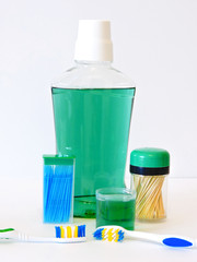 Bottle and glass of mouthwash on bath shelf with toothbrush. Dental oral hygiene concept. Set of oral care products.Flat lay composition with manual toothbrushes  and oral hygiene products.   