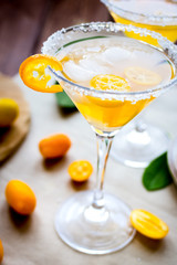 cocktail with kumquat on wooden background
