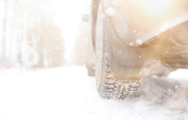 Obraz na płótnie Canvas Car on a snowy winter road in fields.