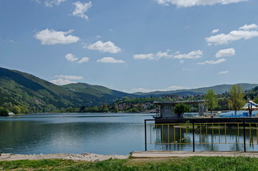 Naklejka premium Look toward environment of springtime picturesque dam with mineral baths, resort village Pancharevo in Plana mountain and waterside of Lozen mountain, Sofia, Bulgaria 
