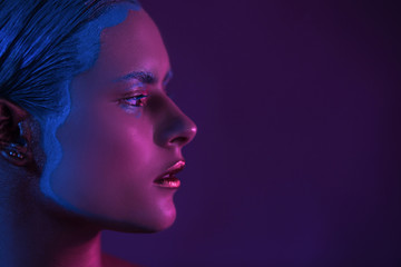 Magenta Half Face of Beautiful Young Girl High Fashion Model in Neon Light