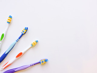 Flat lay composition with manual toothbrushes on white background.Toothbrush and toothpaste.op view, flat lay. Minimal concept, space for text.set of multicolored toothbrushes on white.