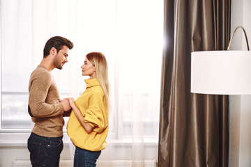 Fototapeta premium Lovers in hotel. Couple holding hands in rental appartment