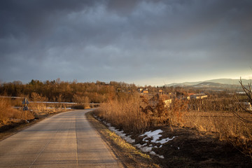 Winter rural scene at sunset with bits of snow