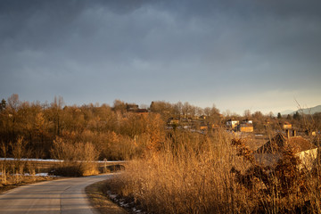 Winter rural scene at sunset with bits of snow