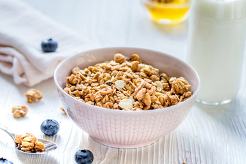 Fitness breakfast with muesli, honey and milk on white table