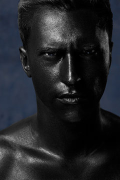 a man in black make-up. portrait in dark paint. Art photography portrait