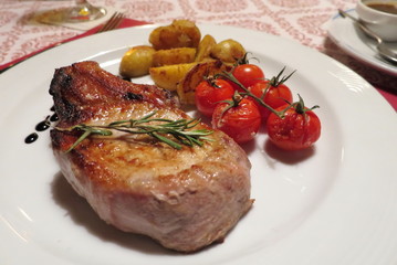 Beef or pork steak with tomato and potato grilled on white plate. Food concept. 