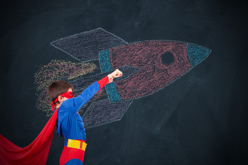 boy in disguise of superhero and car on the blackboard